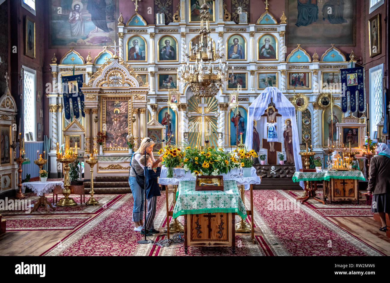 Mutter und Kind Blick auf Blumen in bunten Heiligtum der russisch-orthodoxen Kirche (Parafia prawosławna pw. Opieki Matki Bożej w Puchłach) im Land Stockfoto