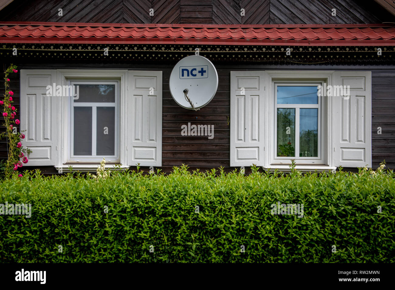 Außenseite der Kabine - Haus mit weissen Fensterläden auf Windows und Satelliten zu Anschlussgleis in Trześcianka das "Land der offenen Rollläden', Polen, Stockfoto