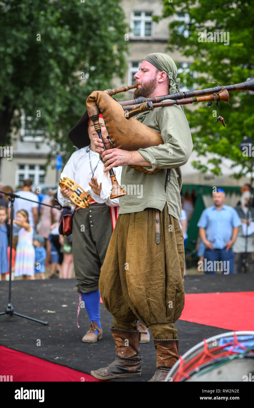 Musiker, gekleidet in der mittelalterlichen Periode Kostüme spielen traditionellen Dudelsack und Tamburin für Zuschauer bei der jährlichen St John's Fair - Jahrmarkt Świętojański Stockfoto
