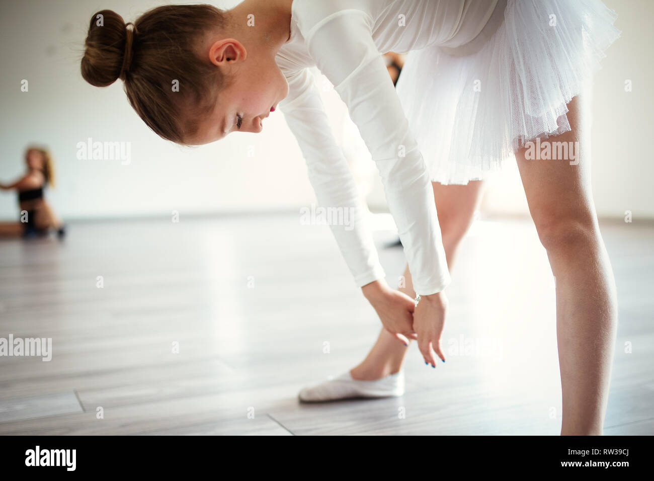 Junge Ballerina in Tutu üben Tanzschritte. Junge Mädchen im Ballett Kleid in der Tanzschule. Stockfoto