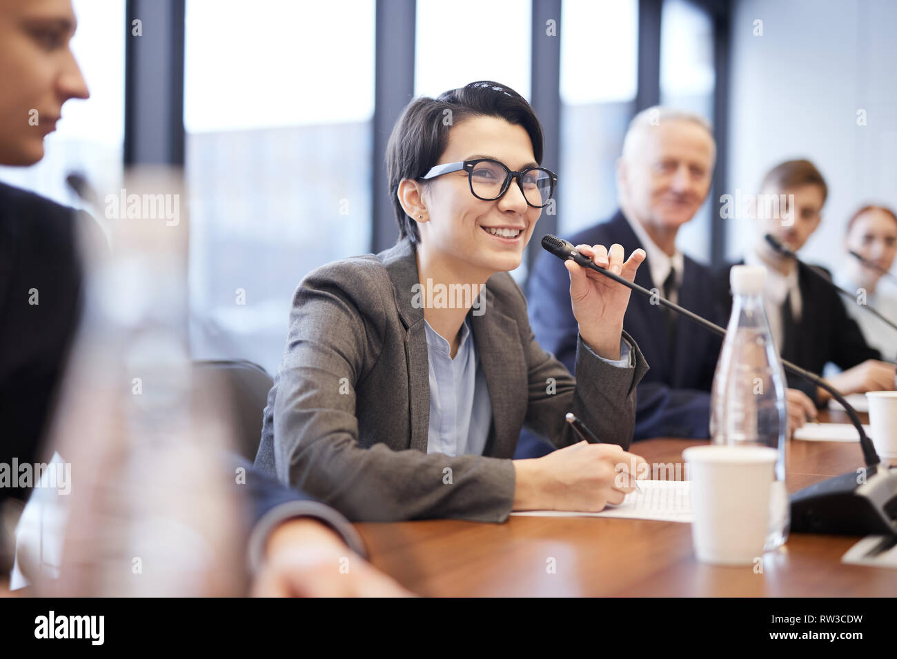 Portrait von lächelnden Geschäftsfrau zu sprechen Mikrofon während der Pressekonferenz oder Seminar, kopieren Raum Stockfoto