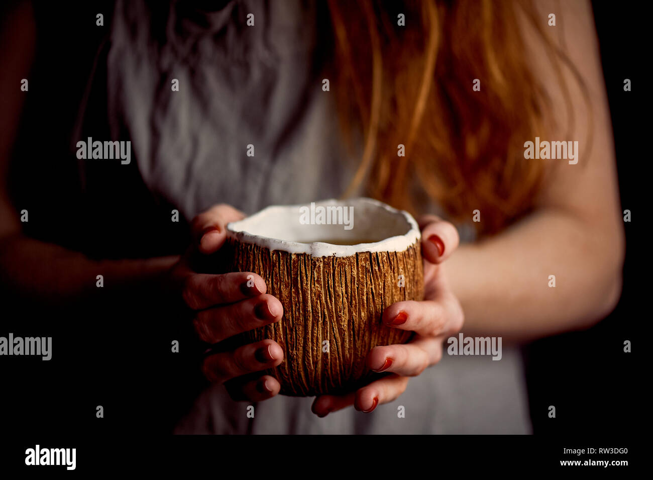 Rothaarige Mädchen mit einem dampfenden Getränke. Kaffee, Tee oder Kakao. Handgefertigte Keramik Stockfoto