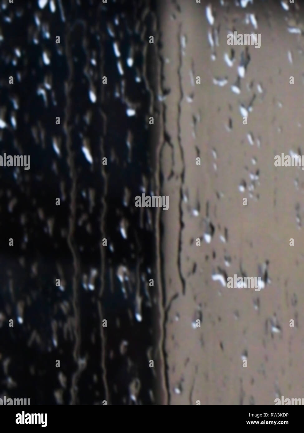 Defokussiertem Hintergrund Detail der nassen Random regen Tropfen spritzen und unten fließt ein Glasfenster einen stürmischen Herbst Nacht Stockfoto