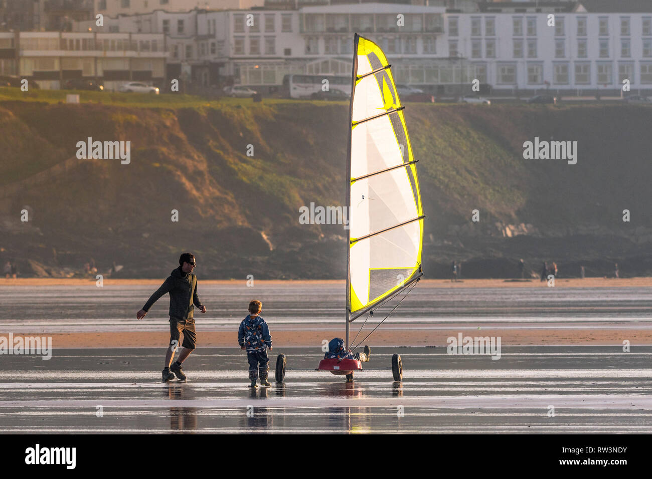 Ein Vater und seine Söhne Spaß mit einem sand Yacht auf den Fistral Beach in Newquay Cornwall. Stockfoto