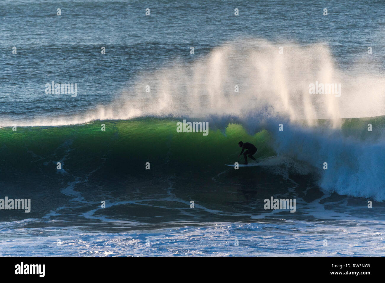 Ein surfer Reiten eine große Welle an der Küste von Newquay Cornwall. Stockfoto