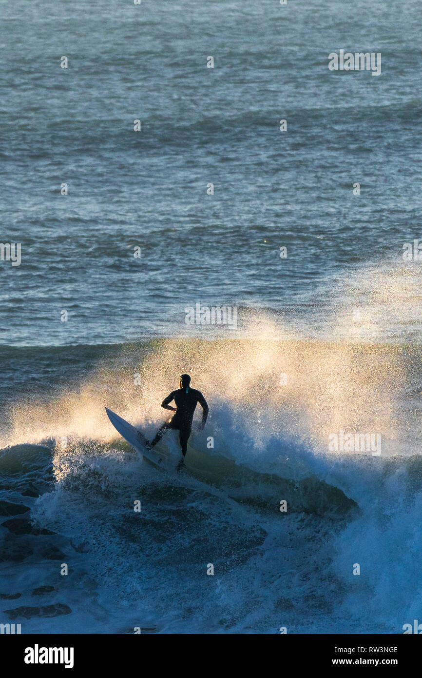 Ein surfer Reiten auf dem Kamm der Welle vor der Küste von Newquay Cornwall. Stockfoto