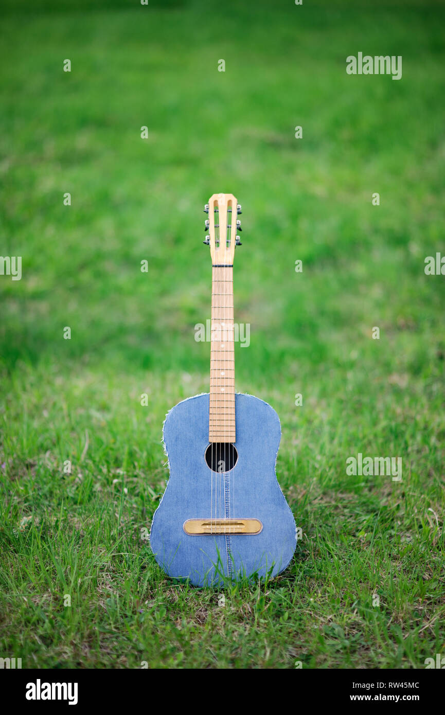 Schöne Vintage Jeans akustische Gitarre mit Nylonsaiten mit Holz Hals stehen auf lebhaftes Grün Gras Stockfoto