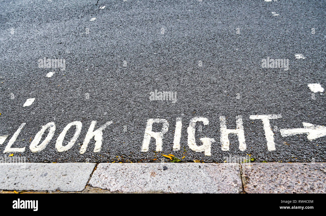 Warnhinweis auf einer Londoner Straße zuerst nach rechts zu schauen. Dies ist für die Touristen, die nicht auf Linksverkehr verwendet werden. Stockfoto