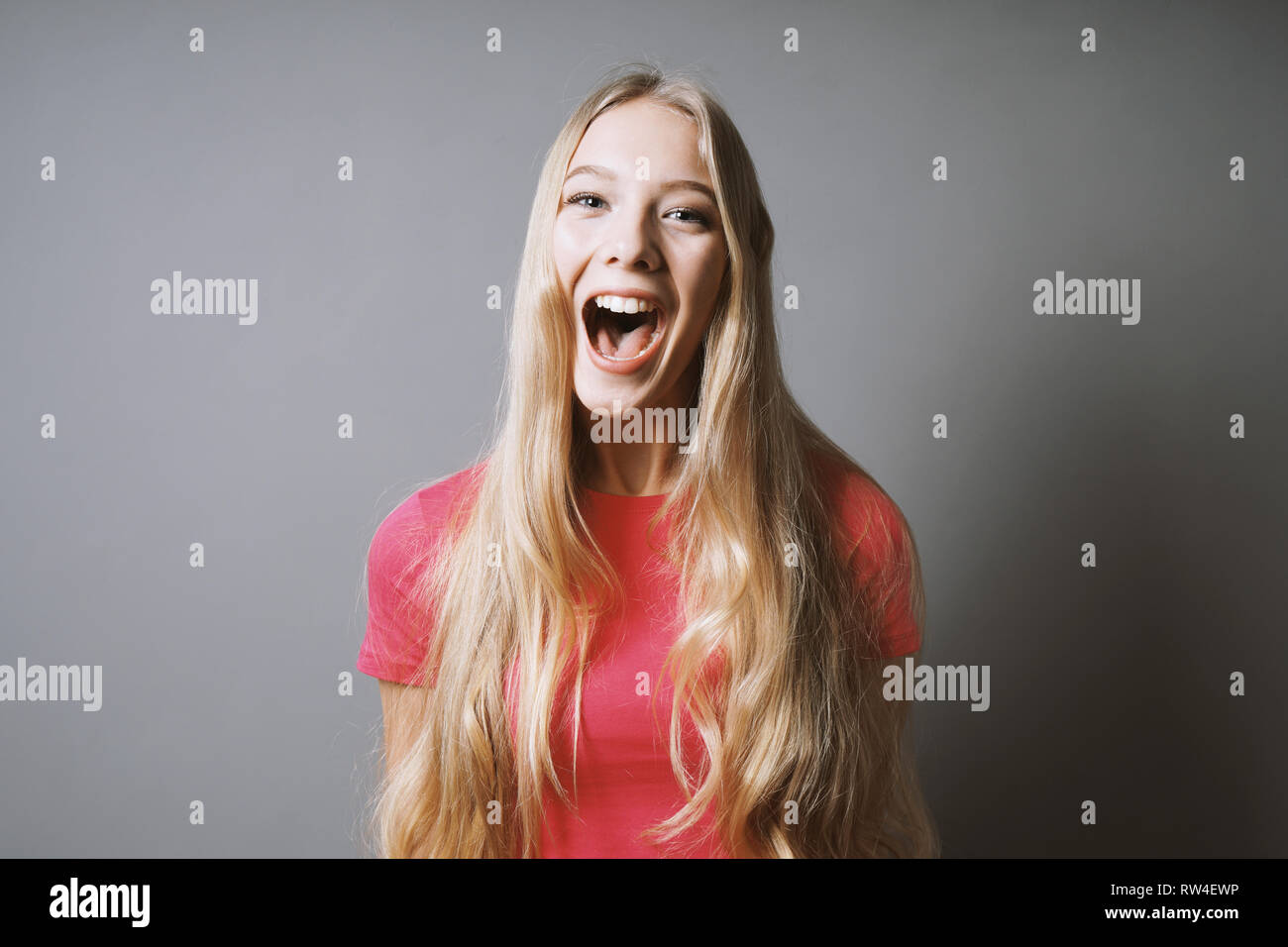 Aufgeregte junge Frau, die vor Freude oder vor Freude schreit Stockfoto
