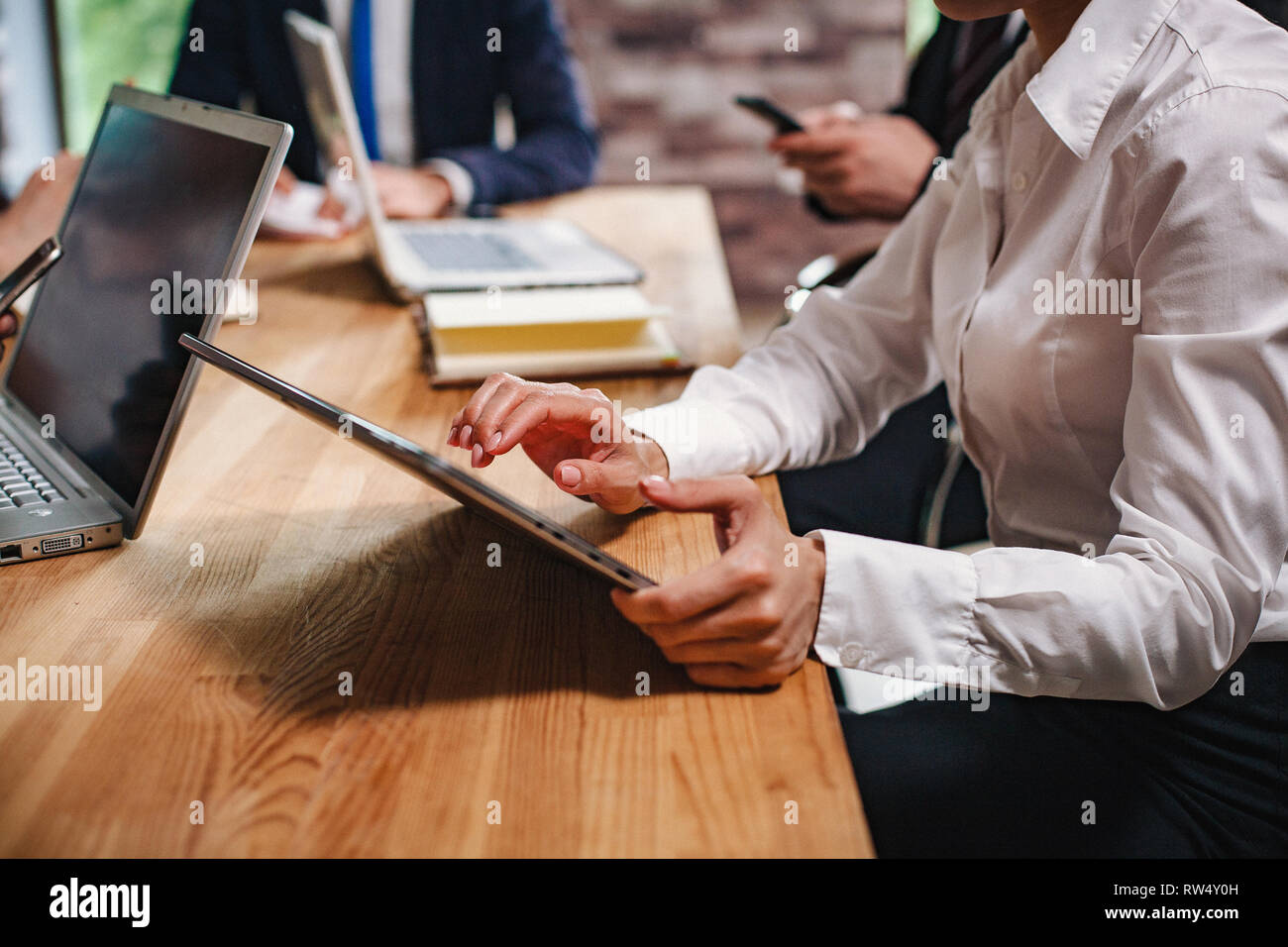 Gruppe Junger Geschäftsleute arbeiten im Büro. Frau mit Laptop. Selektiver Fokus auf die Hände. Stockfoto
