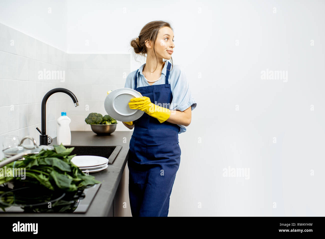 Junge Frau in Schürze Gefühl beim Abwasch in der Küche zu Hause langweilig  Stockfotografie - Alamy