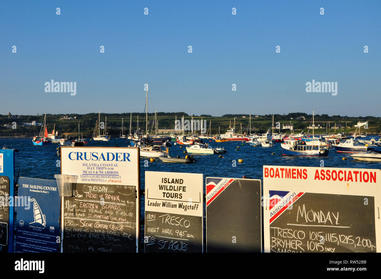 Abendsonne leuchtet die Aushänge an den schwarzen Brettern, in der die Bootsfahrten von Hugh Town, St Mary's auf den äußeren Inseln der Scilly-inseln Archipel. Stockfoto