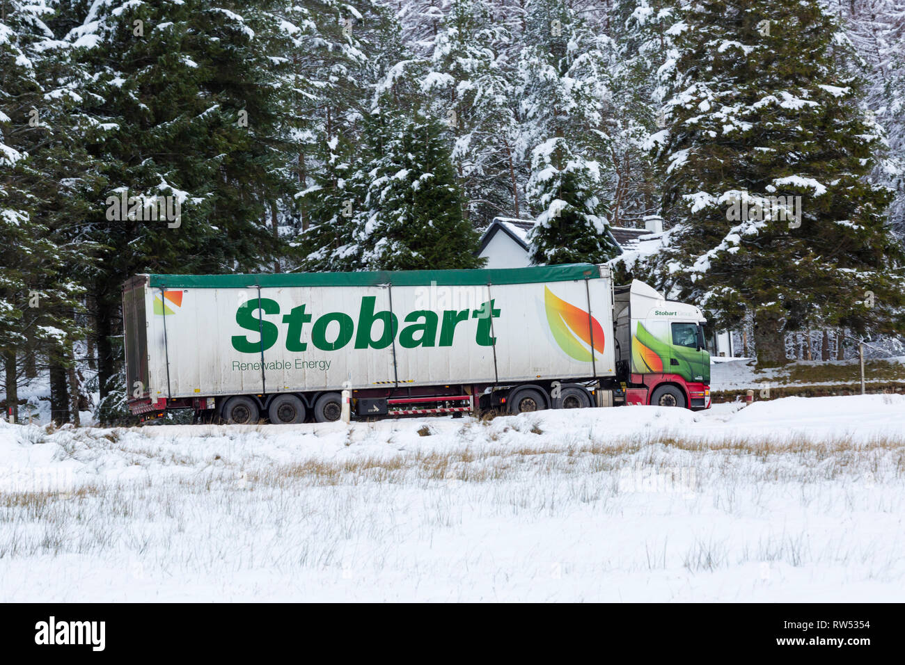 Stobart Truck, den das Fahrzeug entlang der A82 Straße am Tag der Winter mit Schnee um an Rannoch Moor, Glencoe, Highlands, Schottland im Winter Stockfoto