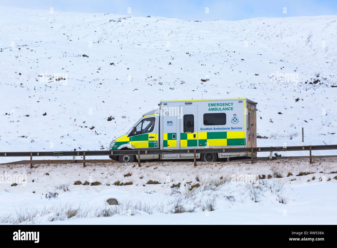 Rettungswagen Scottish Ambulance Service, den das Fahrzeug entlang der A82 Straße am Tag der Winter mit Schnee um an Rannoch Moor, Highlands, Schottland Stockfoto