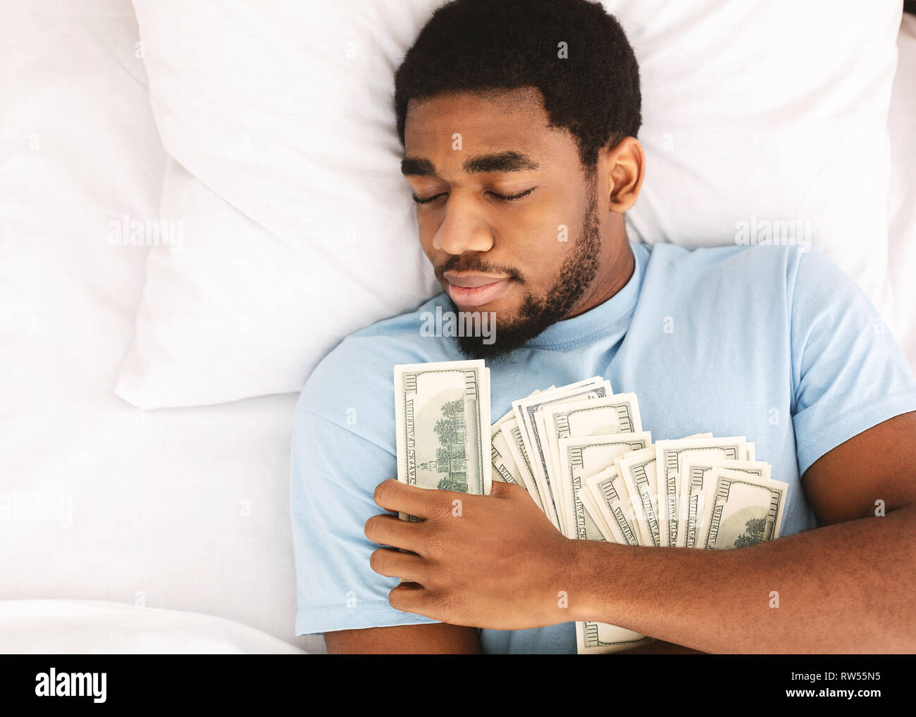 Mann schlafen mit vielen Banknoten Stockfoto