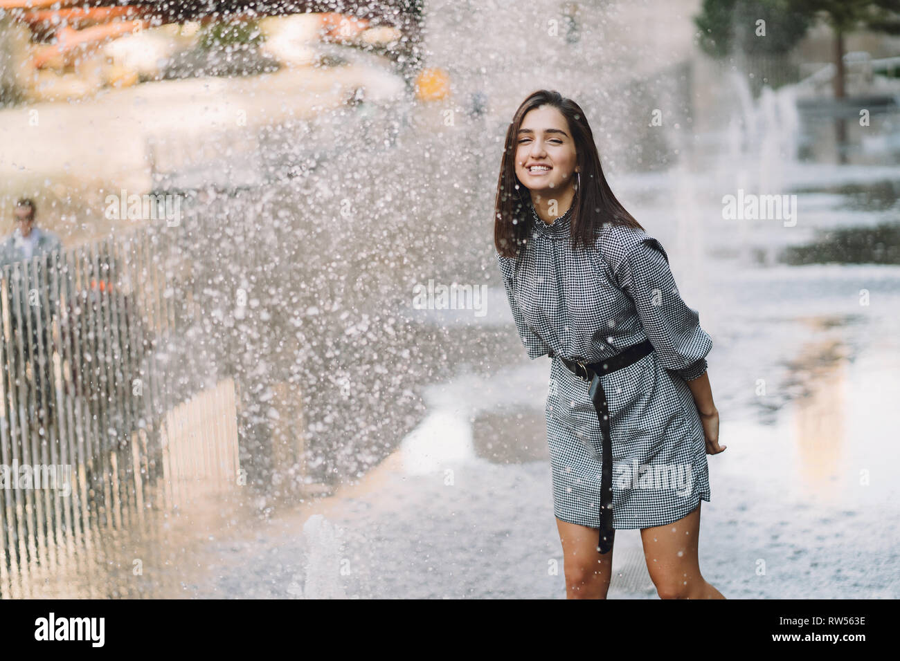 Mädchen spielen und tanzen um auf einer nassen Straße Stockfoto