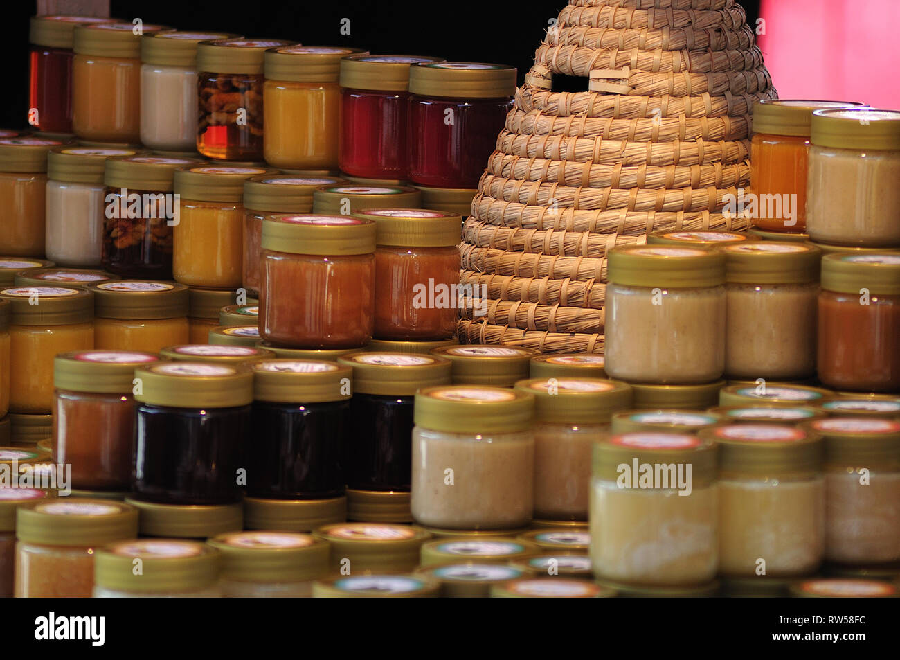 Sortiment von verschiedenen Honig am Wochenmarkt, Stall mit Korb Bienenstock eingerichtet Stockfoto