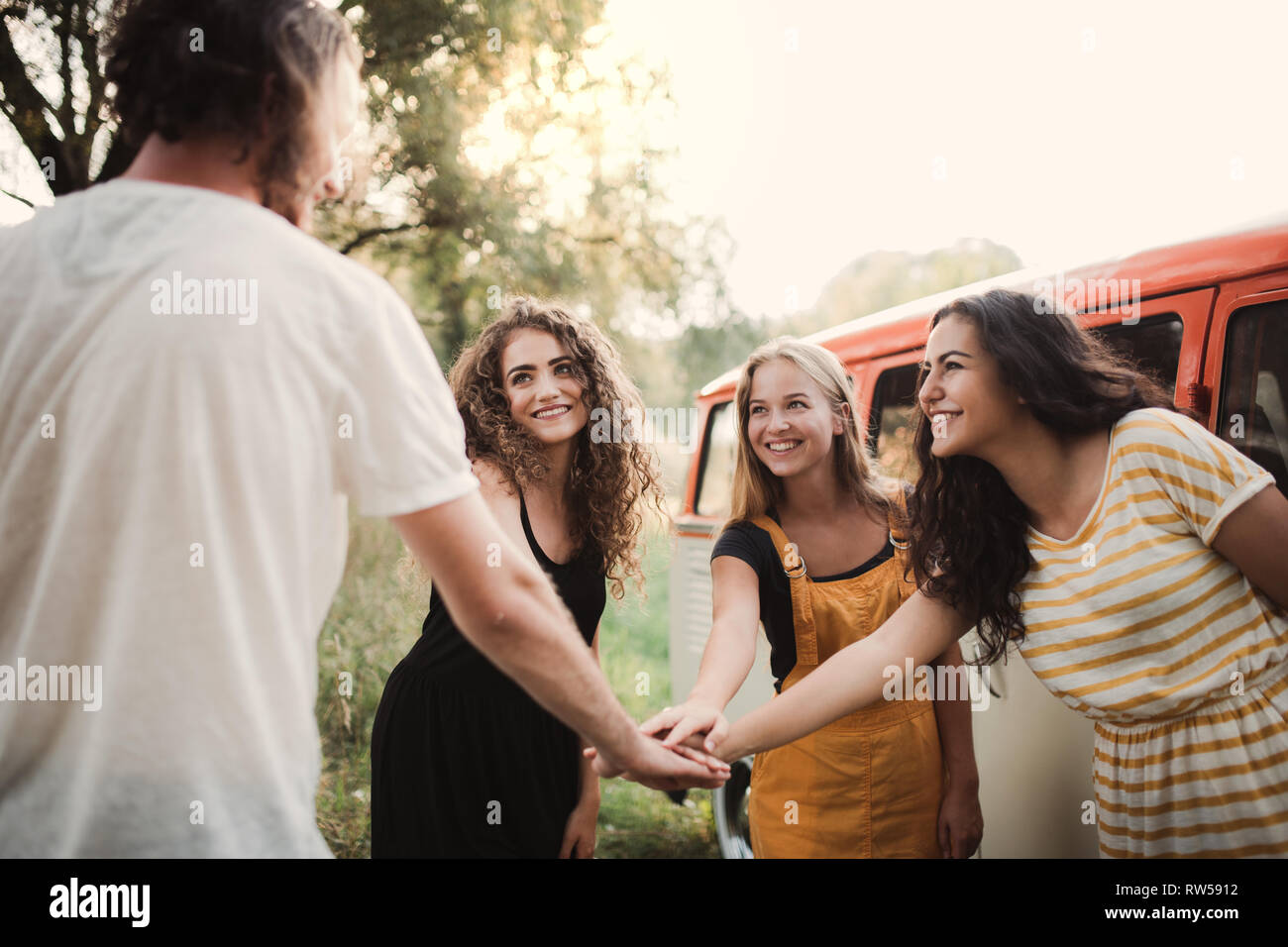 Eine Gruppe junger Freunde auf einem Roadtrip durch die Landschaft, die Hände zusammen. Stockfoto
