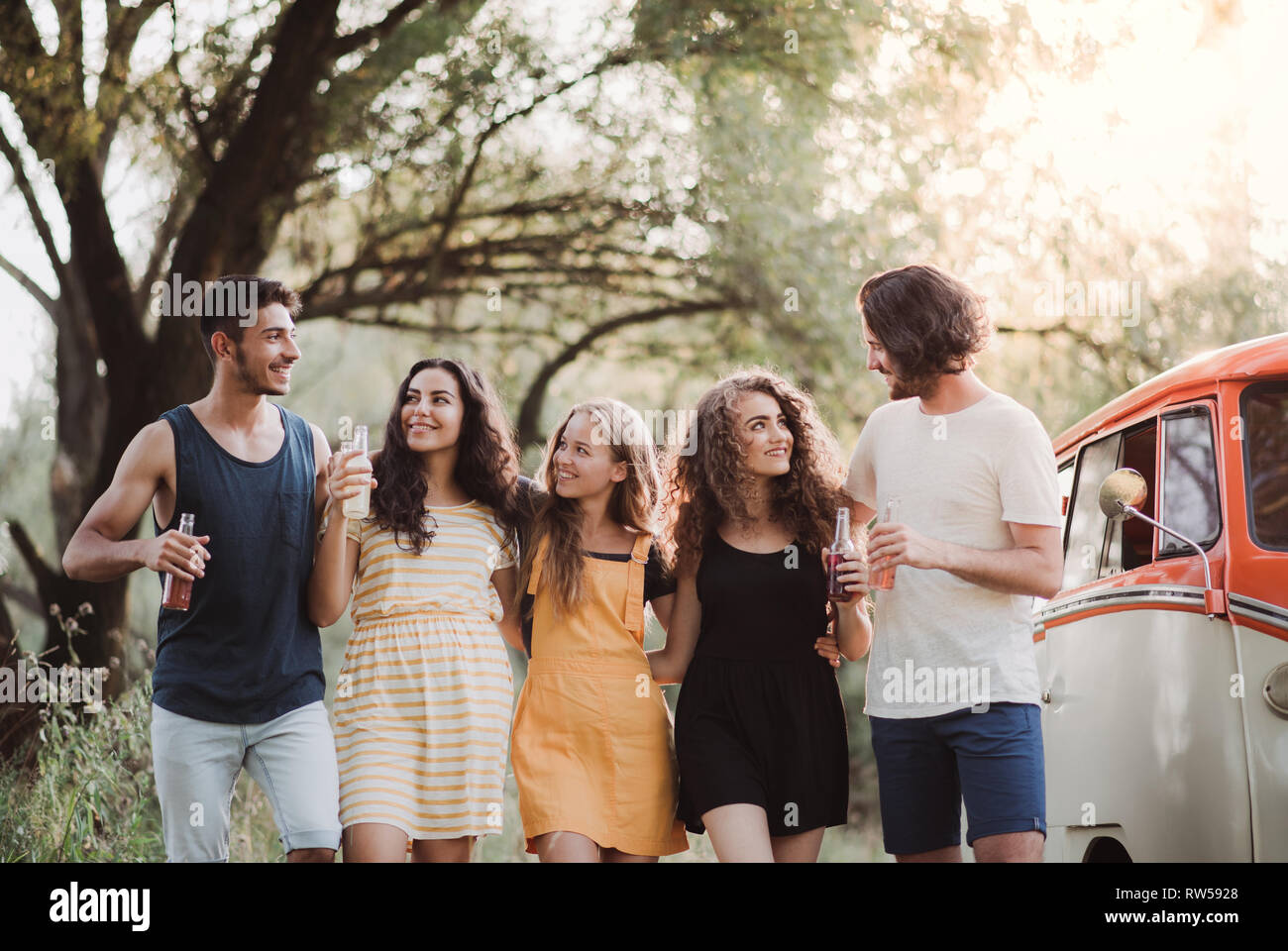 Eine Gruppe junger Freunde auf einem Roadtrip durch Landschaft, Flaschen und Wandern. Stockfoto