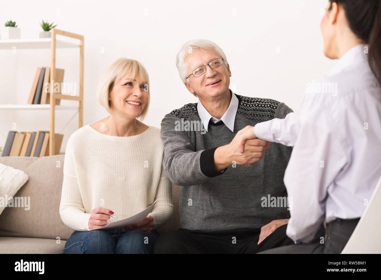 Gerne älteres Paar Abdichtung Vertrag mit Finanzberater Stockfoto