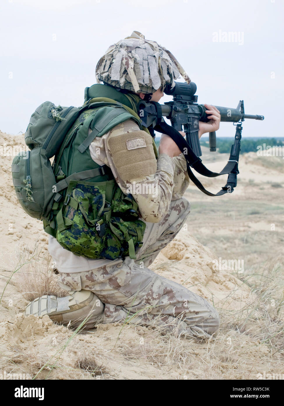 Soldat in der Wüste einheitlich sein Gewehr abzielen. Stockfoto