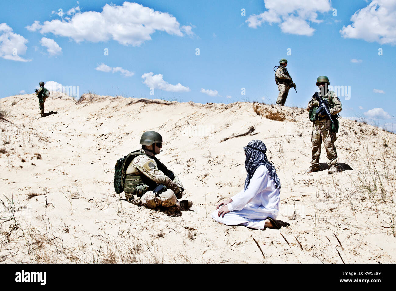 Verhandlungen mit einem muslimischen Krieger, während Soldaten bewachen die Perimeter. Stockfoto
