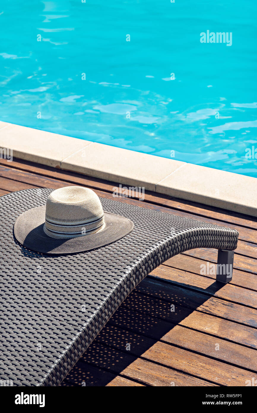 Szene aus Rattan Stuhl Bett mit Frau Hut auf Schwimmbad Stockfoto