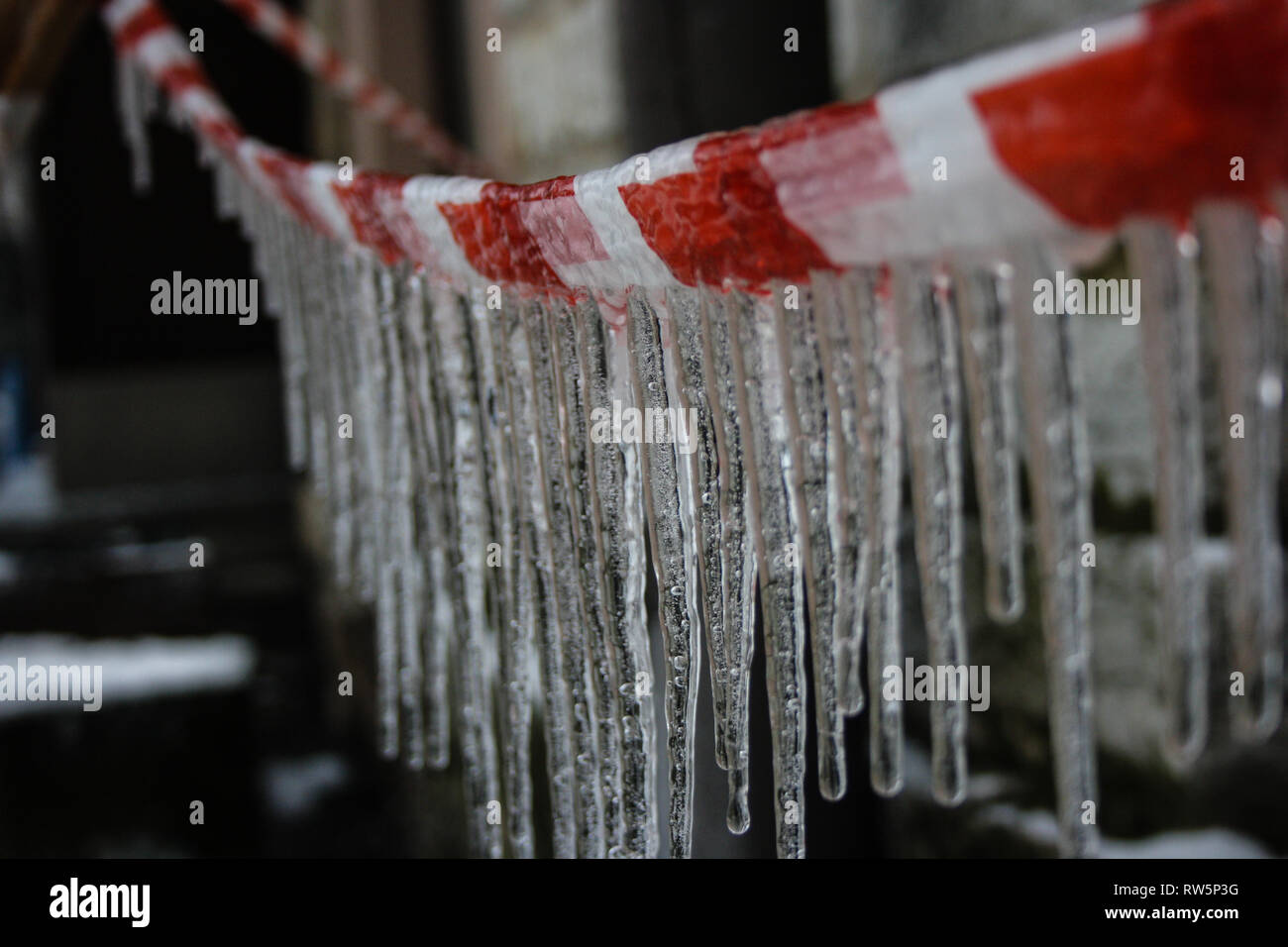 Eiszapfen auf einem Absperrband in Tallinn, Estland. Winter, kalt, Temperaturen unter Null. Stockfoto