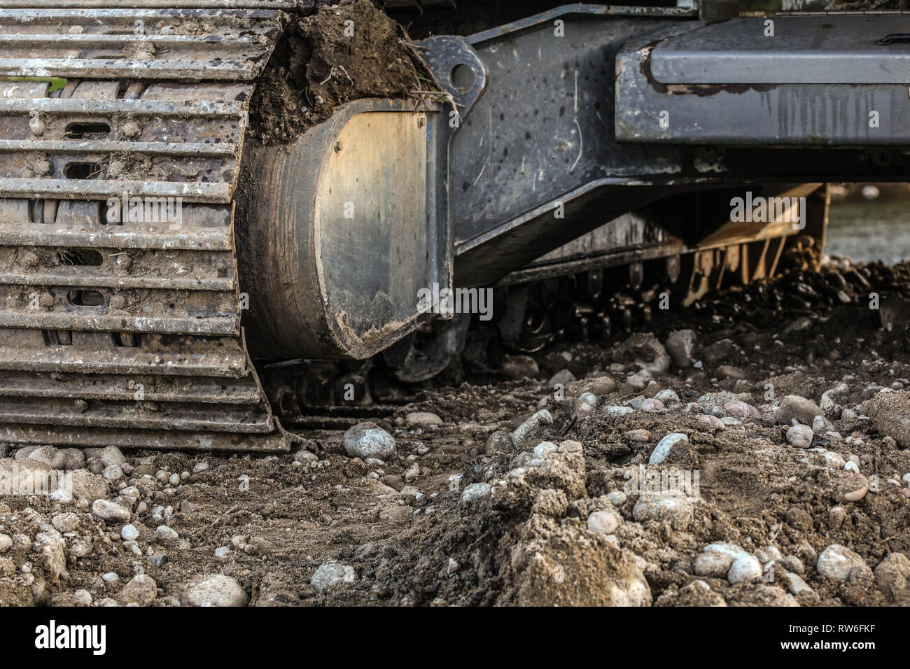 Schwere Hydraulikbagger (Digger) Track detail, einige Steine im Vordergrund. Abstrakte Industrie/Bau Hintergrund. Stockfoto