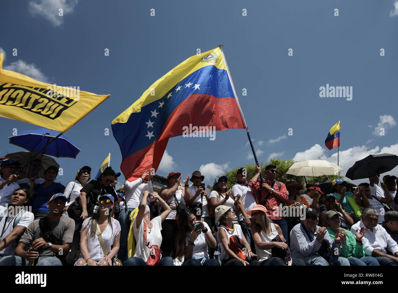 Ein Mann gesehen, winkt ein riesiges Venezolanische Flagge während einer Kundgebung zur Unterstützung der Juan Guaido. Juan Guaido, der venezolanischen Opposition, wo sich viele Nationen als legitime interim Präsident Venezuelas erkannt haben, grüßt seine Anhänger während einer Kundgebung gegen die Regierung von Präsident Nicolas Maduro in Caracas. Stockfoto