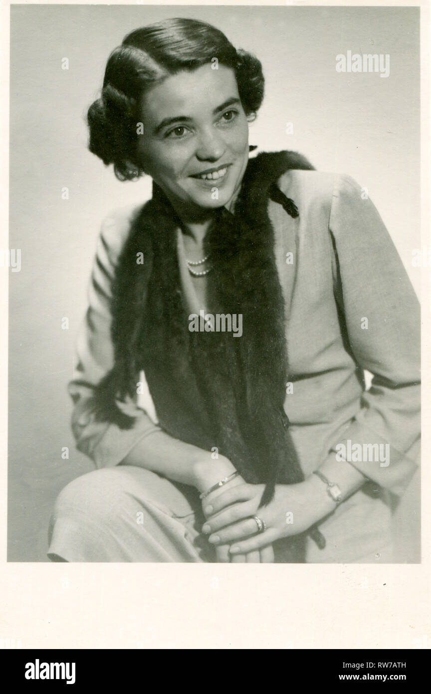Deutschland. 1940er. Eine junge elegante Frau in einen Fuchs Fell Herd. Armband Armband und beobachten. Stockfoto