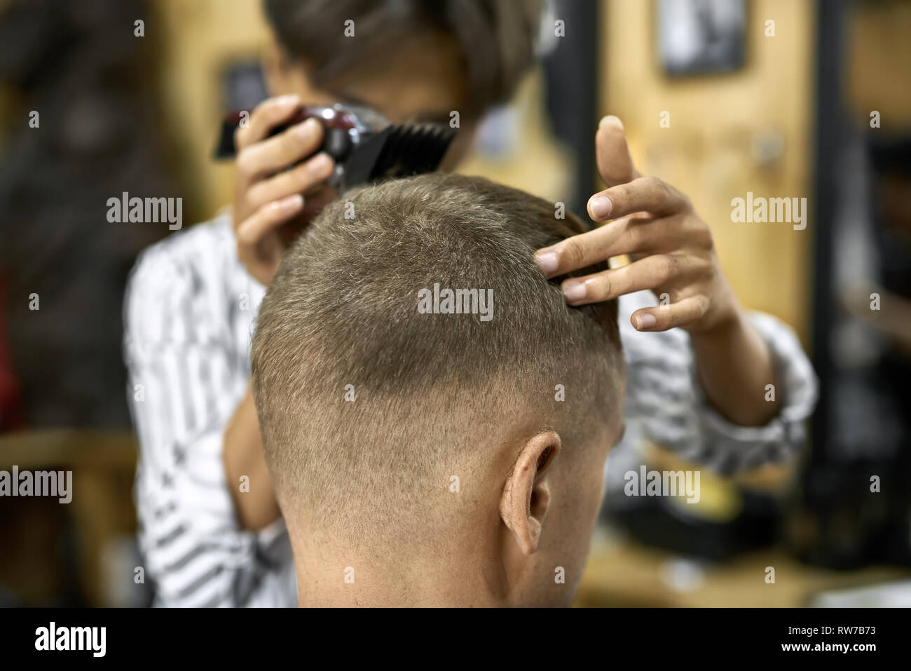 Weisser Kerl In Einem Schwarzen Salon Kap In Der Barbershop Asiatische Friseur In Einem Weiss Schwarzen T Shirt Ist Schneiden Seine Haare Mit Hilfe Des Burgund Trimmer Clos Stockfotografie Alamy