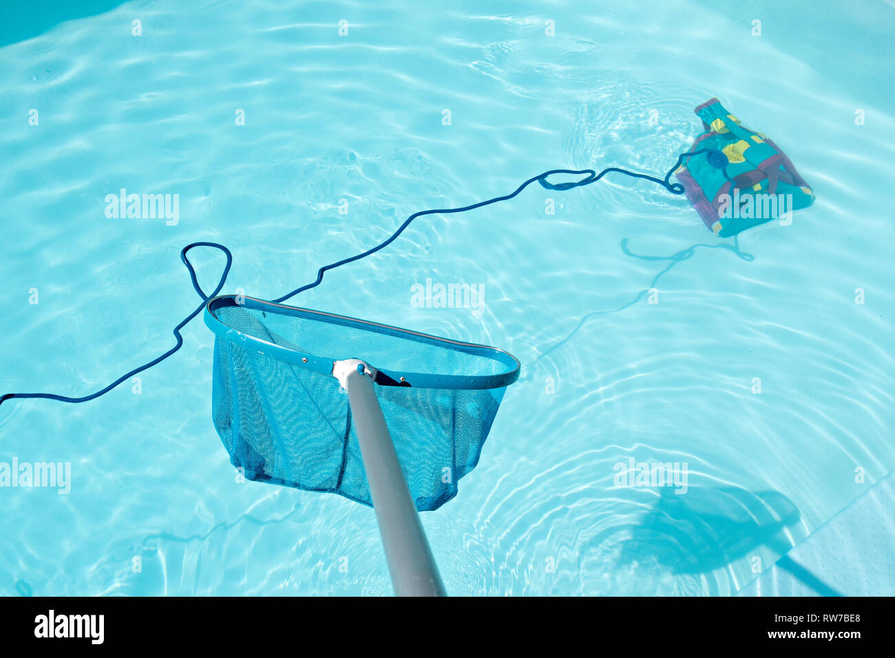 Pool Skimmer und Unterwasser Reinigungsroboter im Pool. Reinigung Pool Konzept Stockfoto