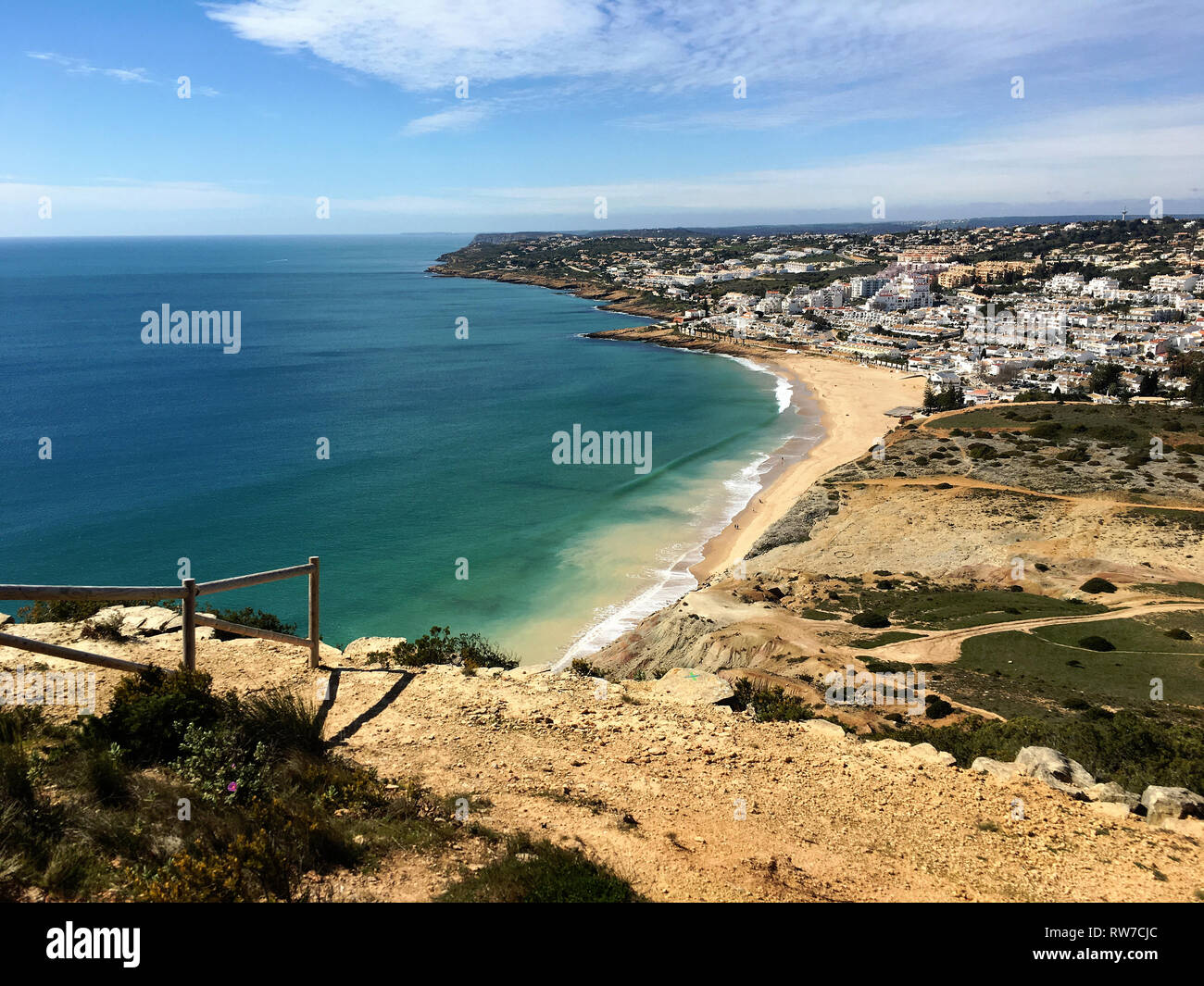 Ruhe enthüllt: Eine abgeschiedene Bank mit Blick auf die riesige portugiesische Meereslandschaft in Algarve's Lagos, wo Natur und Ozean am Horizont verschmelzen Stockfoto