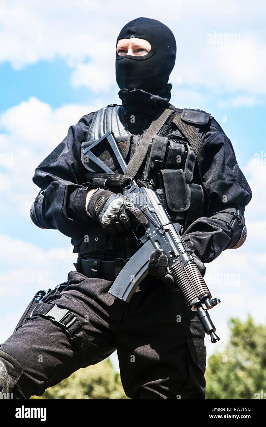 Spec Ops Soldat in schwarzen Uniform und Gesichtsmaske mit seinem Gewehr. Stockfoto