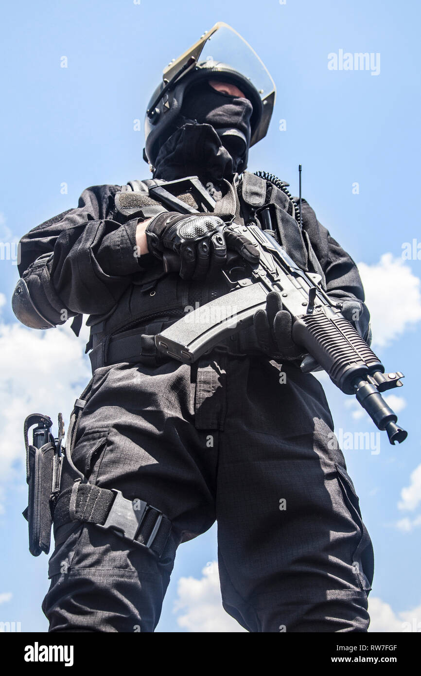 Spec Ops Soldat in schwarzen Uniform und Gesichtsmaske mit seinem Gewehr. Stockfoto