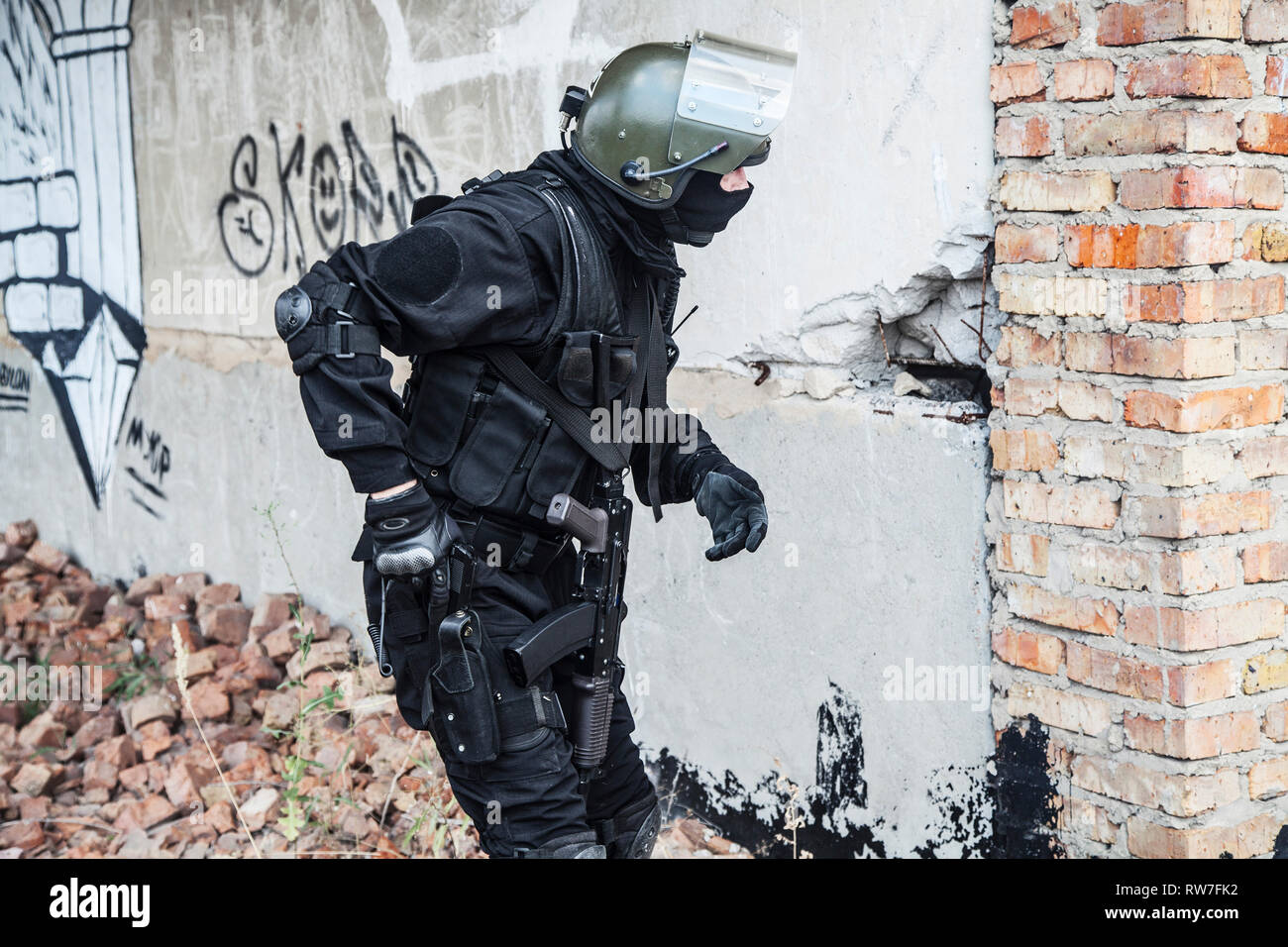 Spec Ops Soldat in schwarzen Uniform und Gesichtsmaske seine Pistole. Stockfoto