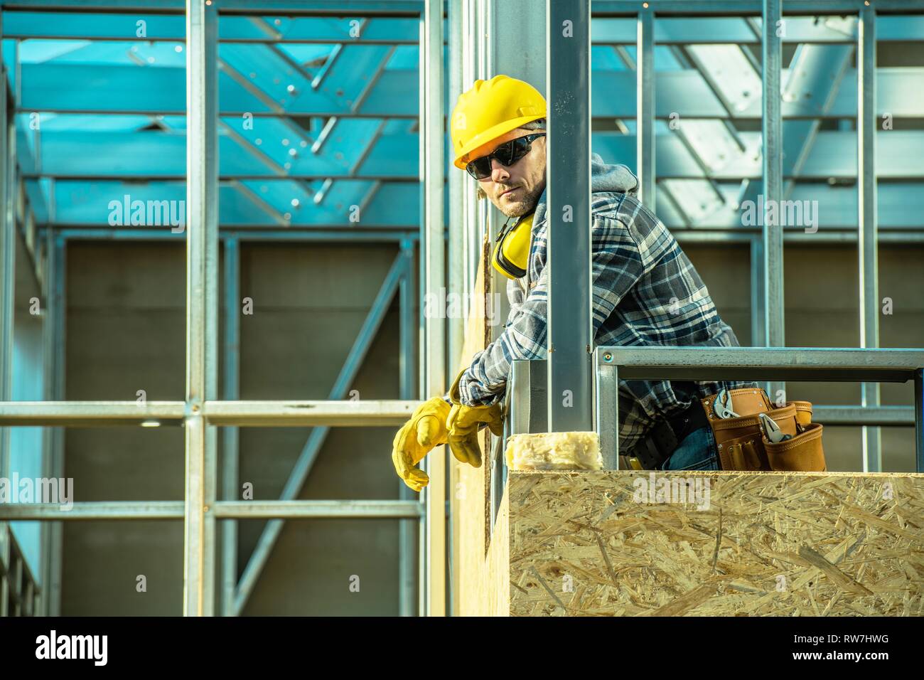 Professionelle Bauarbeiter und das Skelett Stahlrahmen der entwickelten Gebäude. Kaukasische Mitarbeiter in seinem 30. Stockfoto