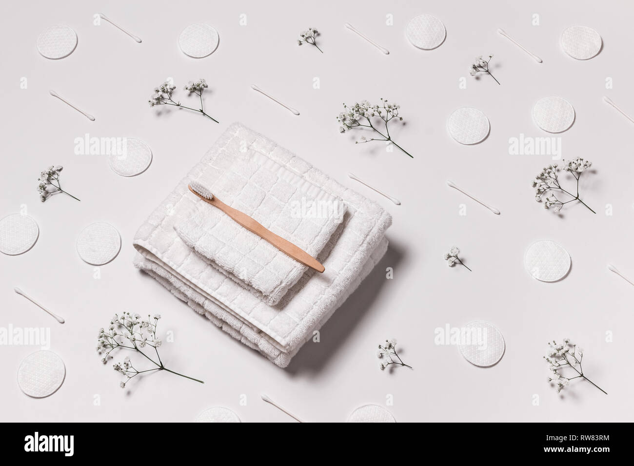 Weiße Handtücher, Zahnbürste, Wattepads, Wattestäbchen und Baby's Atem Blumen auf weißem Hintergrund. Schönheit und Körperpflege. Stockfoto