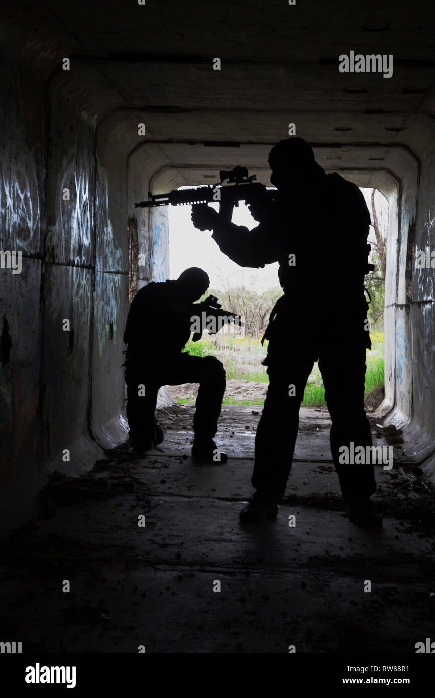 Silhouette von Special Forces Betreiber mit Waffen in den Tunnel. Stockfoto