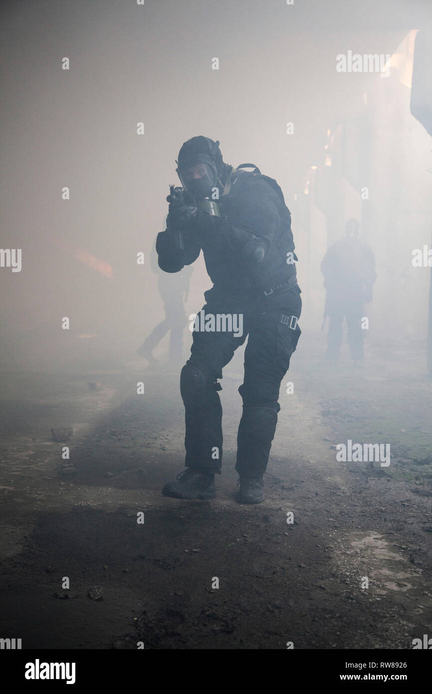 Special forces Operator in schwarzer Uniform im Rauch. Stockfoto