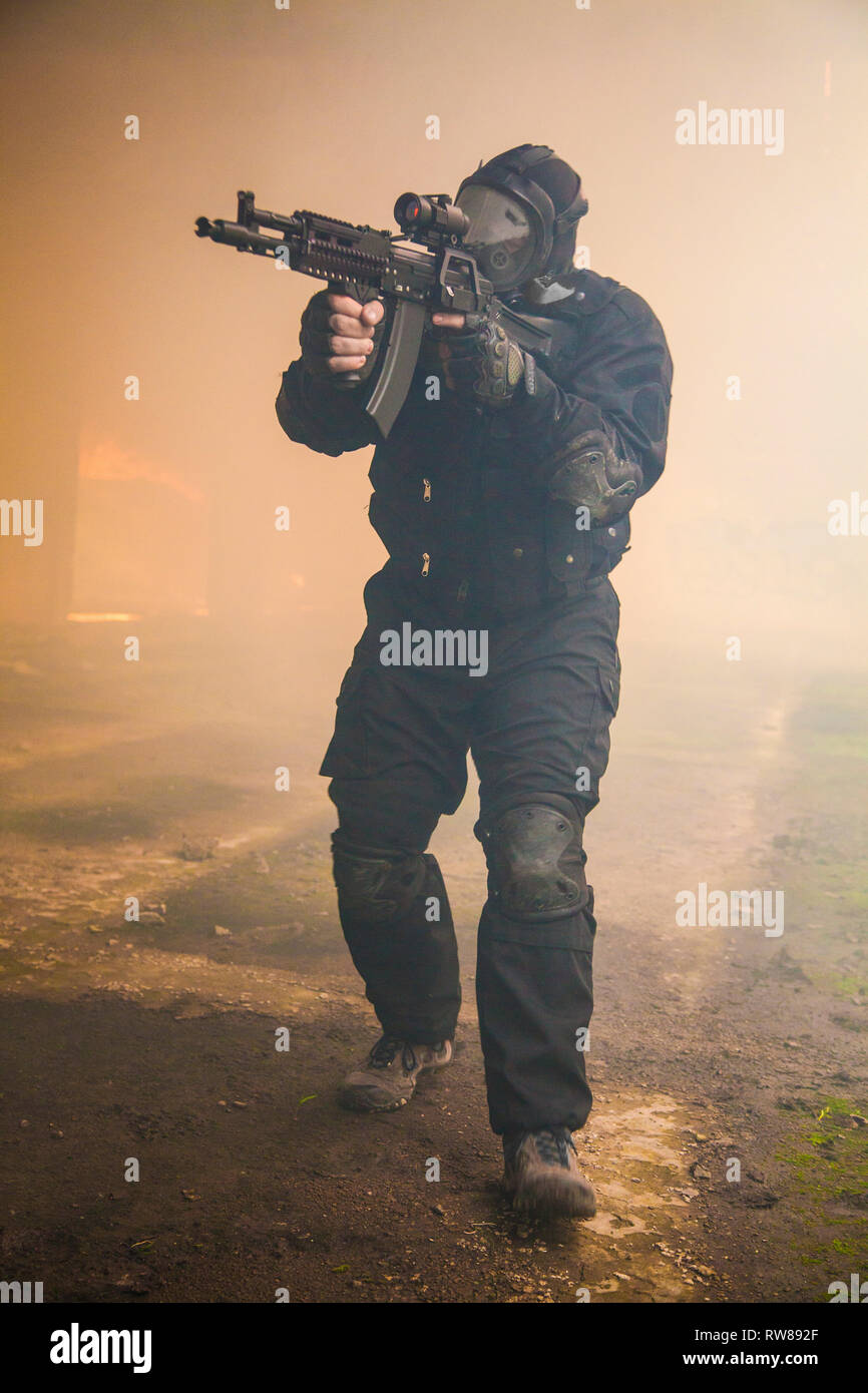 Special forces Operator in schwarzer Uniform im Rauch. Stockfoto