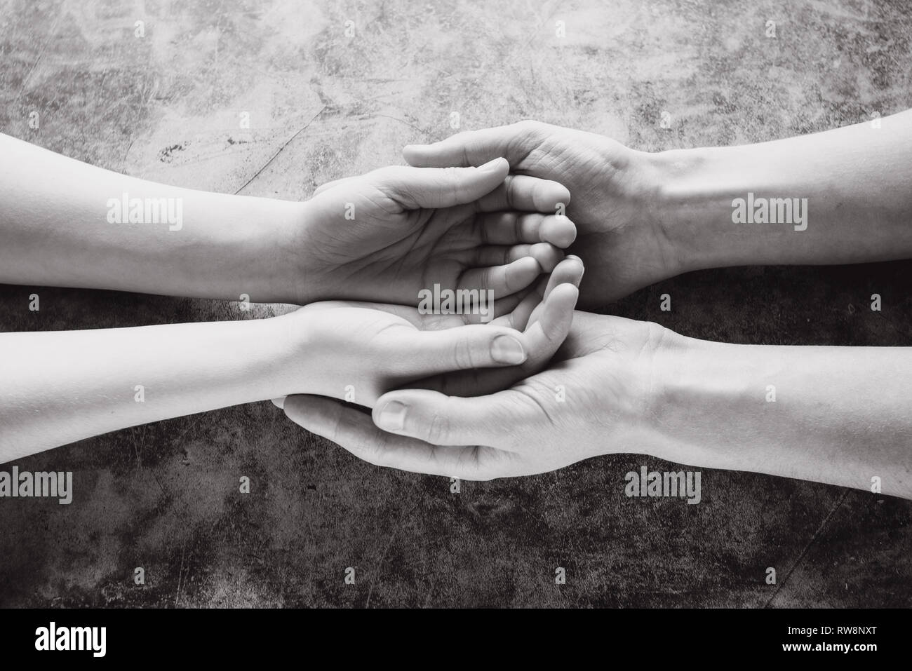 Junge Familie Hand in Hand mit Hilfe, Schutz und Unterstützung Symbol. Gemeinsame Hoffnung Konzept Stockfoto