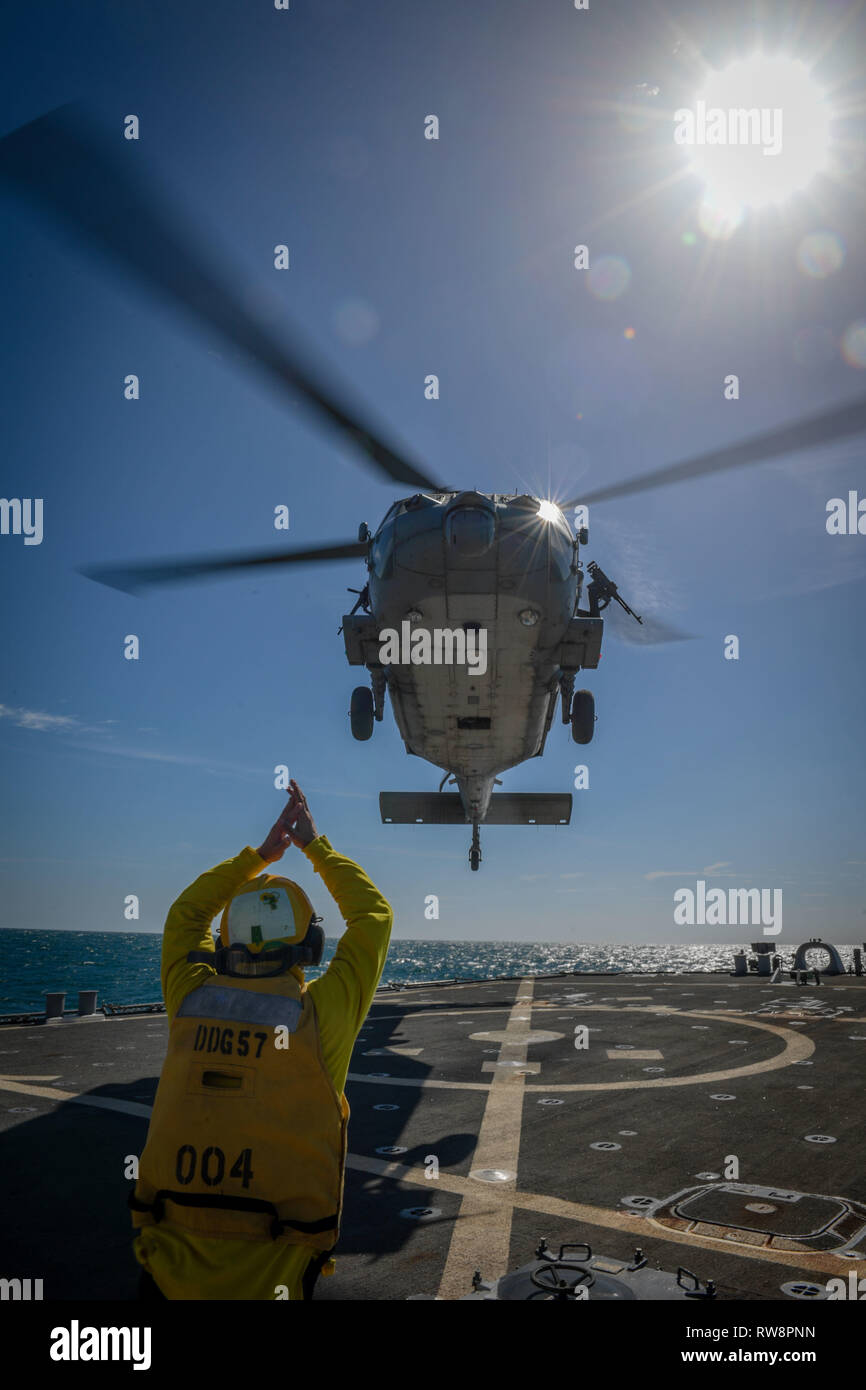 ARABIAN GULF (Mar. 1, 2019) Eine MH-60S Sea Hawk Hubschrauber zum "Ladegeräte" der Hubschrauber Meer Combat Squadron (HSC) 26 Zieht aus der Arleigh-Burke-Klasse geführte Anti-raketen-Zerstörer USS Mitscher (DDG57). Mitscher ist in die USA 5 Flotte Bereich der Maßnahmen zur Unterstützung der Marine im Einsatz für die Stabilität und Sicherheit in der Region zu gewährleisten und verbindet das Mittelmeer und den Pazifischen Raum durch den westlichen Indischen Ozean und drei strategischen Punkten ersticken. (U.S. Marine Foto von Mass Communication Specialist 2. Klasse Jakob Milham/Freigegeben) Stockfoto