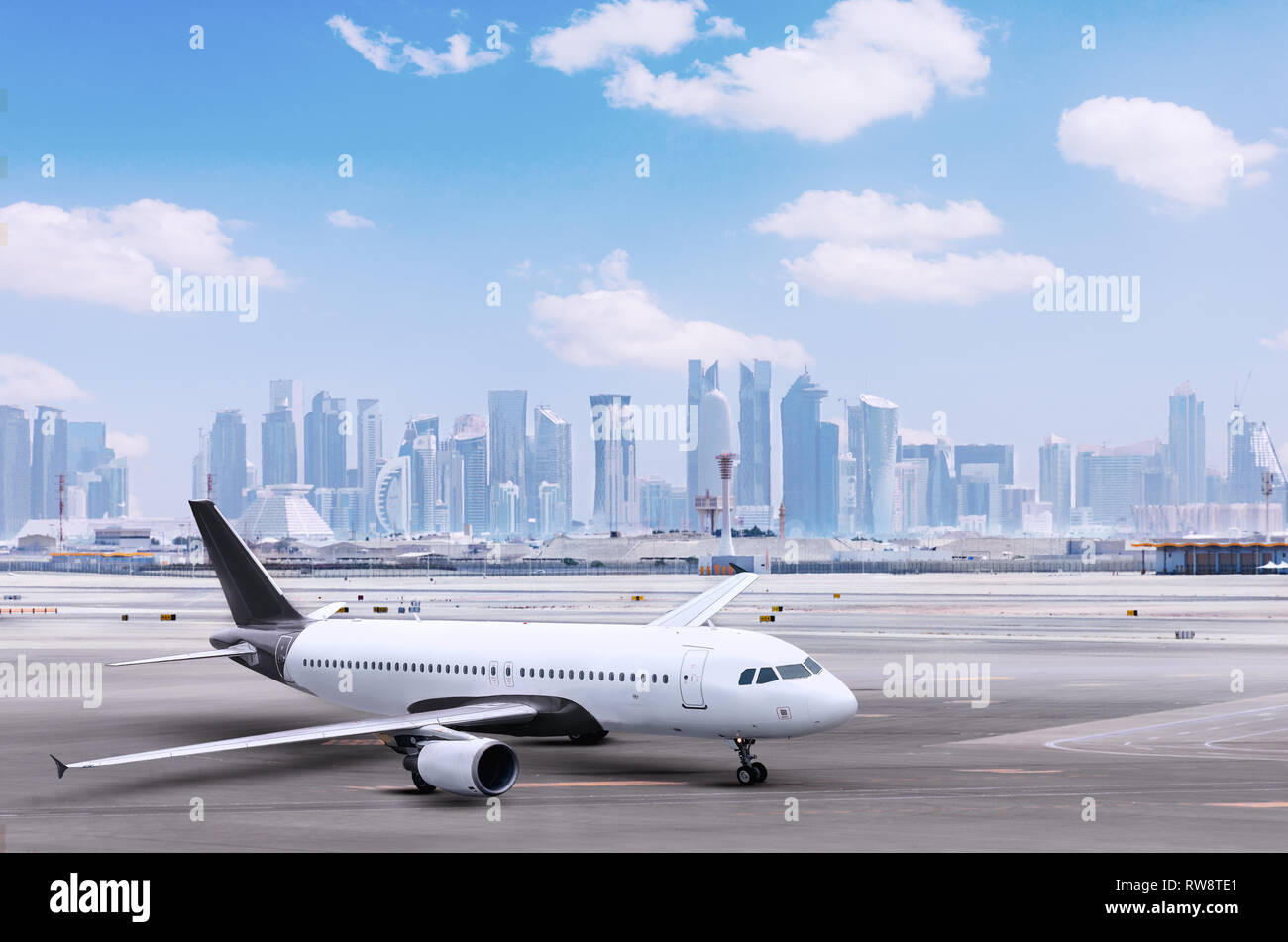 Flugzeug am Flughafen Doha, Stadtbild mit Blick auf die Hochhäuser im Hintergrund. Ebene mit Gebäude, Flugzeuge und Städte, Logistik. Stockfoto