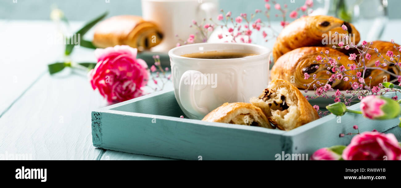 Urlaub mit Tasse Kaffee, frischen Croissants, Brötchen und Schokolade Gartennelke-blumen auf Türkisfarbenem Hintergrund. Kopieren Sie Platz. Stockfoto
