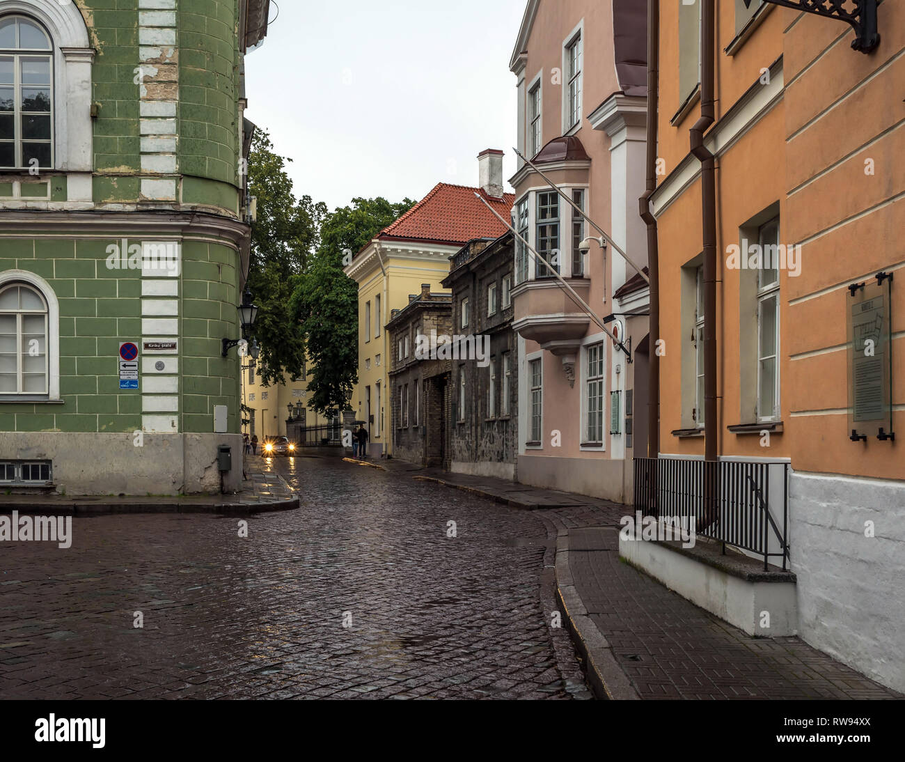 Tallinns Altstadt Straße in Stumpf, trüben regnerischen Abend, mit grauem Himmel und nassen Kopfsteinpflaster Straße. Alte Grün, Rosa und Orange Gebäude in der Altstadt von Tallinn, Stockfoto