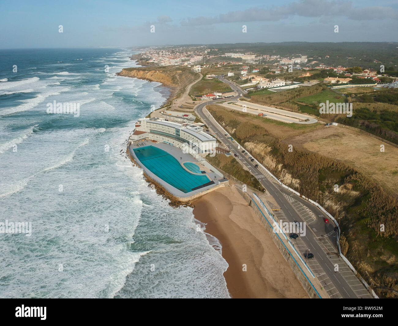 Luftaufnahme von einem großen Sandstrand mit Wellen und einem großen Ocean Pool. Portugiesische Küste Stockfoto