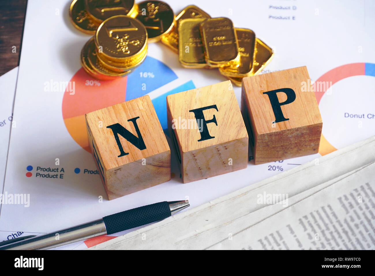 Text "Nfp" auf Holz Würfel mit Gold Bar und die Zeitung auf dem Tisch, wirtschaftliche Daten Konzept Stockfoto