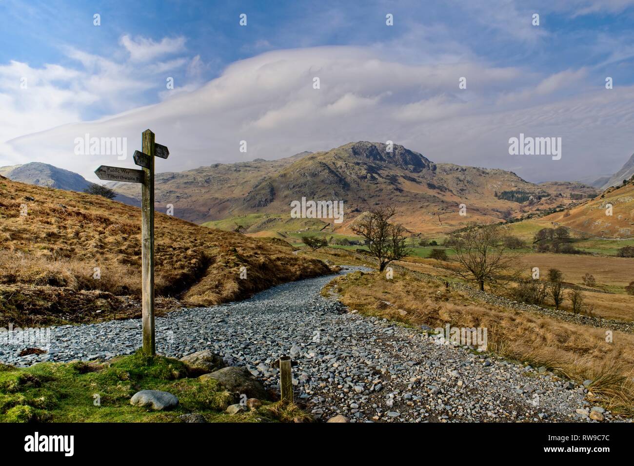 Eine fingerpost an einer Kreuzung der Wege im Little Langdale mit Hecht O'Blisco im Hintergrund Stockfoto